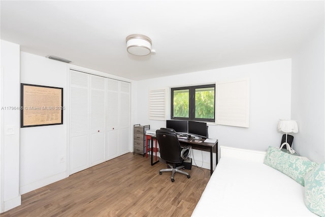 bedroom featuring a closet, light wood-type flooring, and visible vents