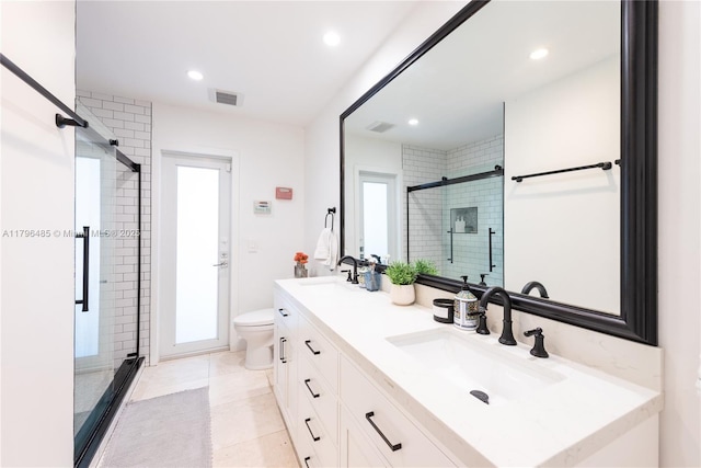 bathroom featuring double vanity, toilet, a stall shower, a sink, and visible vents