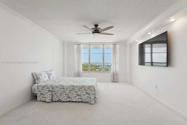 carpeted bedroom featuring baseboards, ceiling fan, crown molding, and a textured ceiling