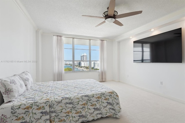 carpeted bedroom featuring ornamental molding, a textured ceiling, and ceiling fan
