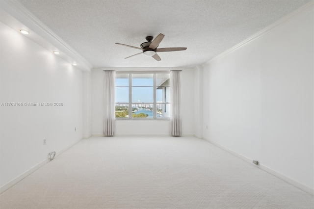 unfurnished room with ornamental molding, a textured ceiling, carpet floors, and a ceiling fan