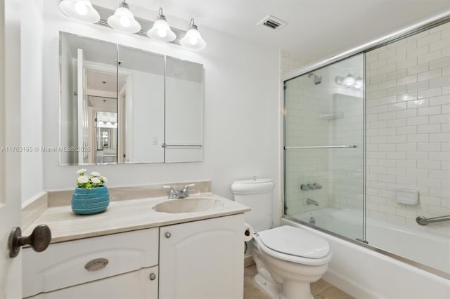bathroom with toilet, visible vents, bath / shower combo with glass door, and vanity