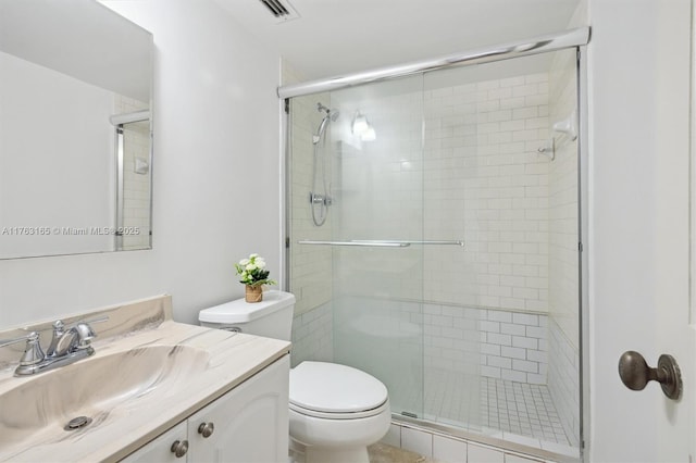 full bath with vanity, toilet, and a stall shower