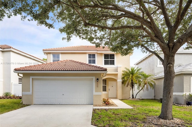 mediterranean / spanish-style home with concrete driveway, stucco siding, an attached garage, and a tile roof