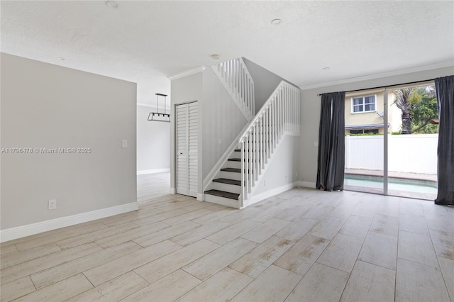 interior space with stairway, a textured ceiling, wood tiled floor, and baseboards
