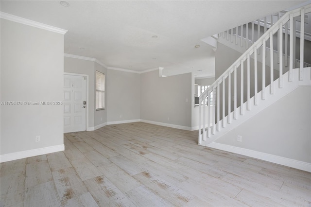 unfurnished living room with stairway, ornamental molding, baseboards, and wood finished floors