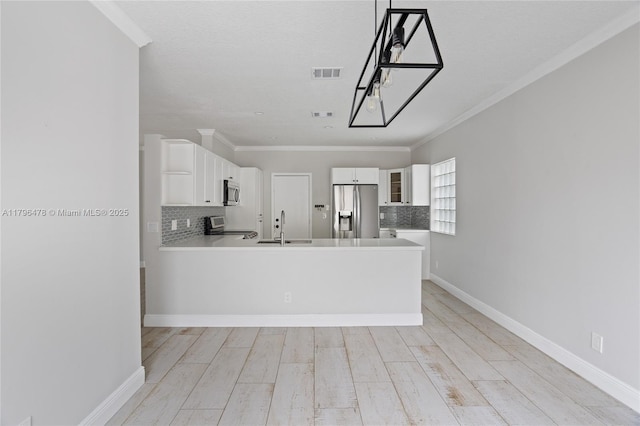 kitchen featuring a sink, white cabinets, visible vents, appliances with stainless steel finishes, and decorative backsplash