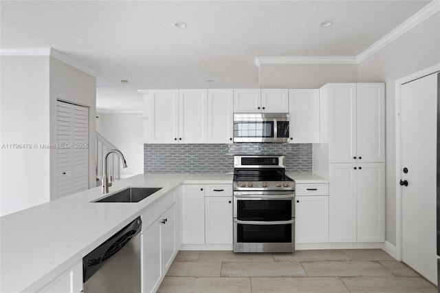 kitchen featuring a sink, a textured ceiling, crown molding, decorative backsplash, and appliances with stainless steel finishes