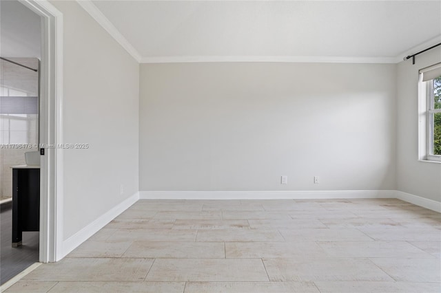 empty room featuring ornamental molding and baseboards