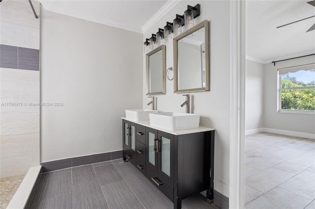 bathroom with a sink, ornamental molding, and baseboards