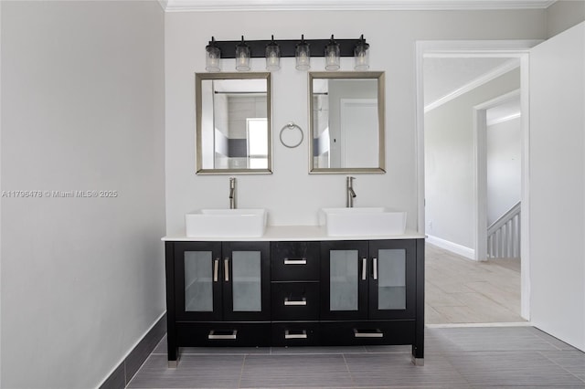 bar with a sink, crown molding, and baseboards