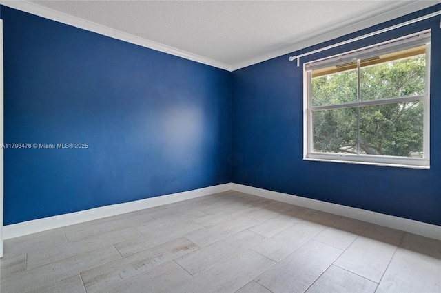 unfurnished room with crown molding, a textured ceiling, and baseboards