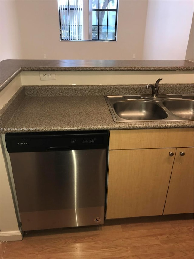 kitchen with stainless steel dishwasher, light wood-style flooring, and a sink