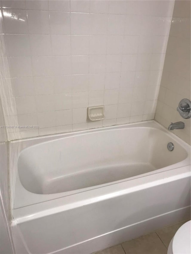 bathroom featuring toilet, tile patterned flooring, and shower / tub combination