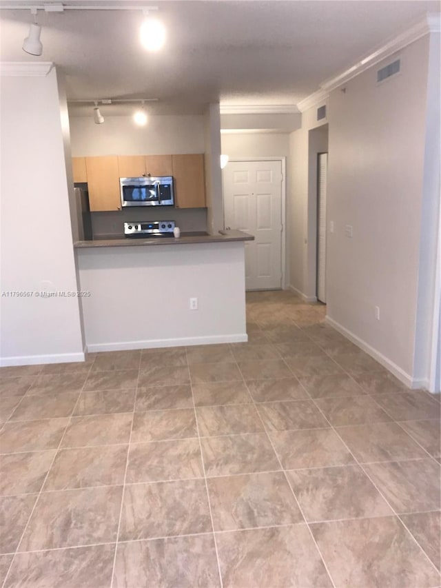 kitchen with visible vents, track lighting, crown molding, dark countertops, and appliances with stainless steel finishes