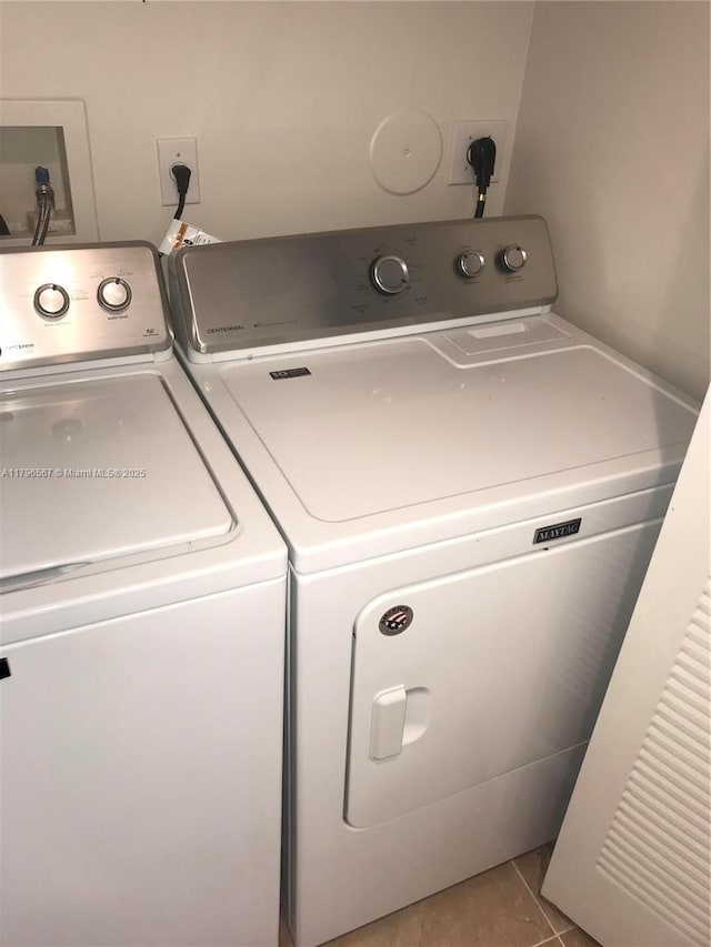 laundry room featuring separate washer and dryer, laundry area, and tile patterned floors