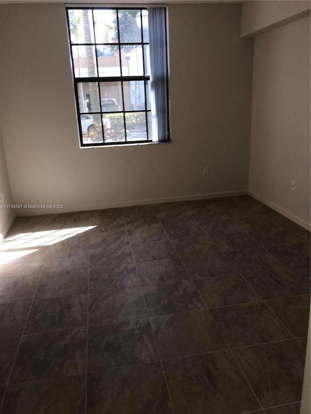 spare room featuring baseboards