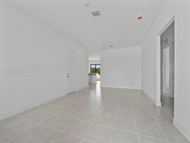 spare room with baseboards, visible vents, and light tile patterned flooring