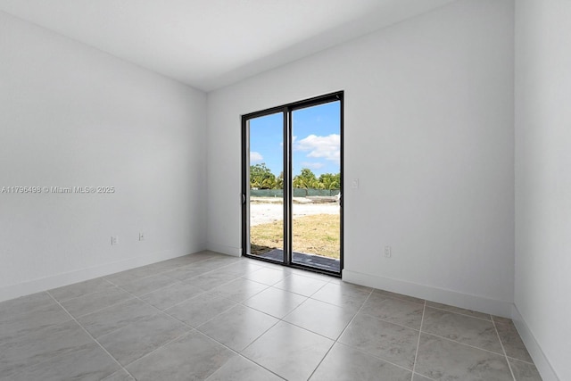 empty room featuring baseboards, light tile patterned floors, and plenty of natural light