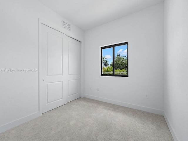 unfurnished bedroom with carpet flooring, visible vents, and baseboards