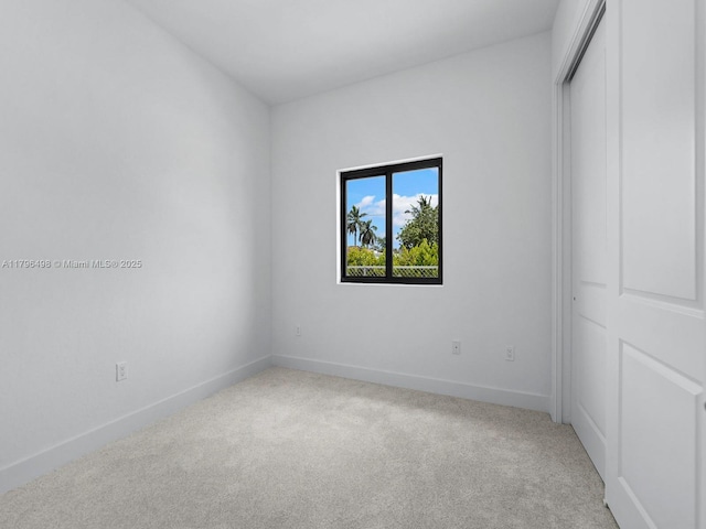 empty room with light carpet and baseboards
