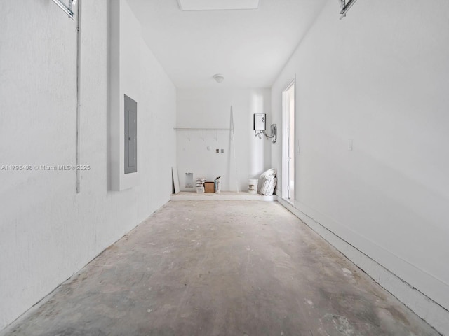 hallway with unfinished concrete flooring and electric panel