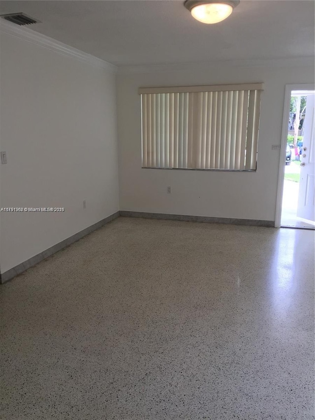 unfurnished room featuring baseboards, crown molding, visible vents, and speckled floor