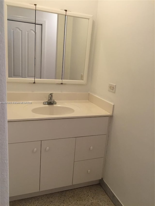 bathroom featuring vanity, baseboards, and speckled floor