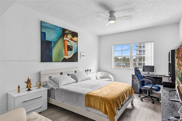 bedroom with a textured ceiling, a ceiling fan, and wood finished floors