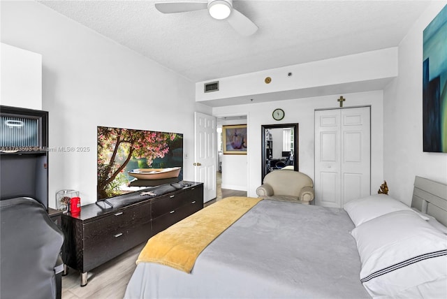 bedroom with a ceiling fan, a closet, visible vents, and a textured ceiling