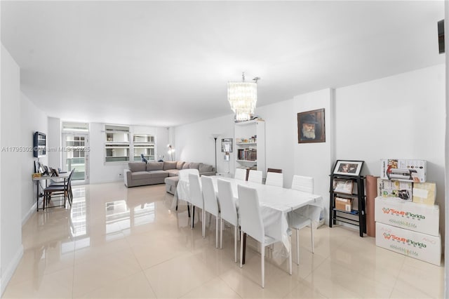 dining space with light tile patterned floors, baseboards, and an inviting chandelier