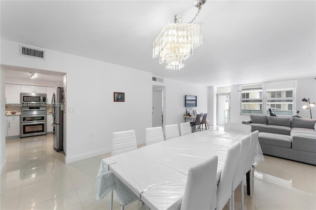 dining room featuring a chandelier, light tile patterned floors, visible vents, and baseboards