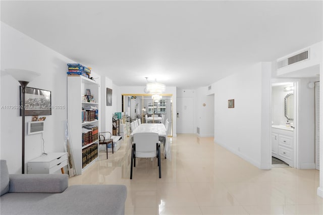 interior space with baseboards, an inviting chandelier, visible vents, and light tile patterned floors