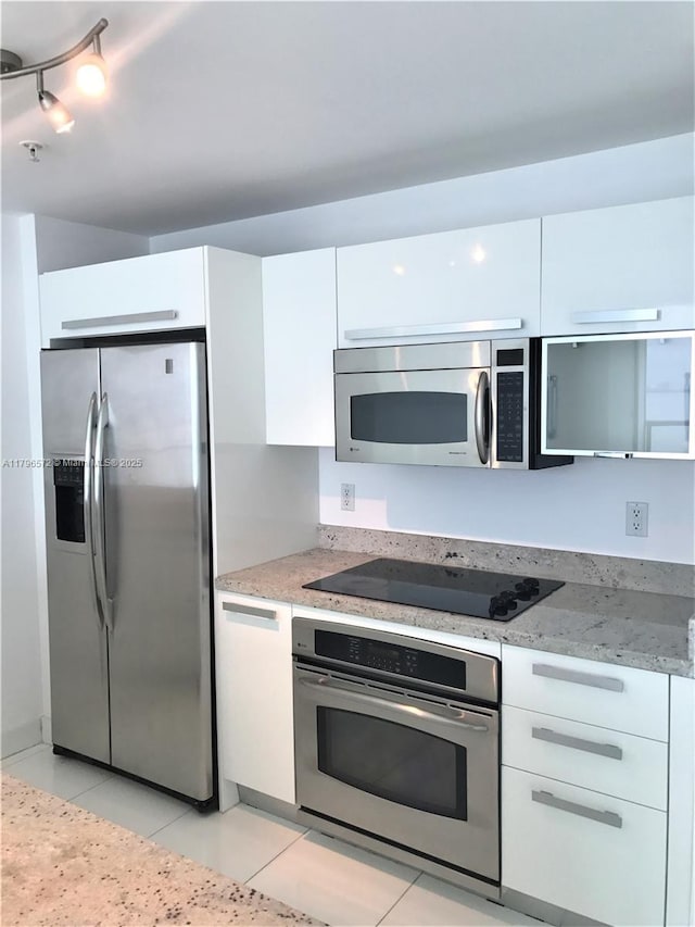 kitchen featuring white cabinets, modern cabinets, and appliances with stainless steel finishes