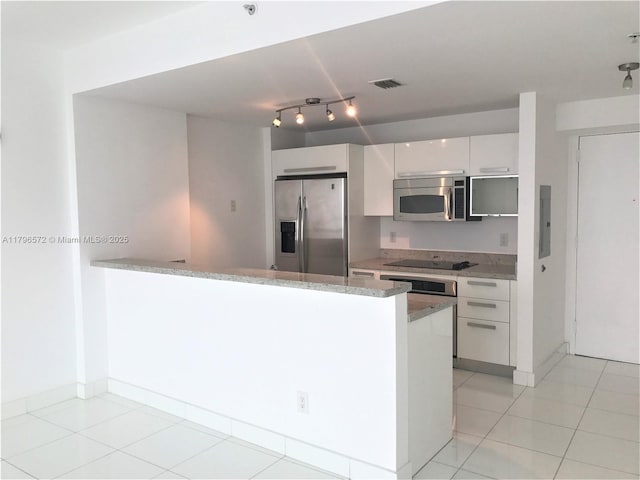 kitchen featuring electric panel, a peninsula, stainless steel appliances, white cabinetry, and light stone countertops