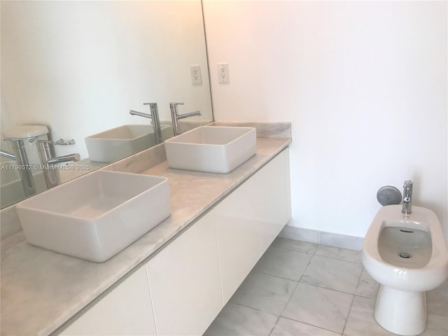bathroom featuring double vanity, a bidet, and a sink