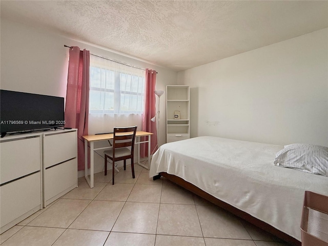 bedroom with a textured ceiling and light tile patterned floors
