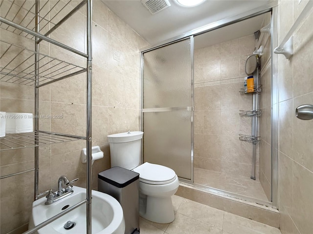 full bathroom with tile walls, a shower stall, visible vents, and tile patterned floors