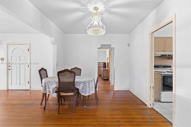 dining area featuring baseboards, a notable chandelier, and light wood-type flooring
