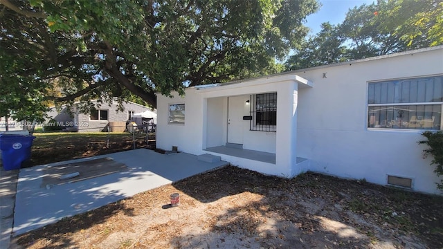 entrance to property with stucco siding and visible vents