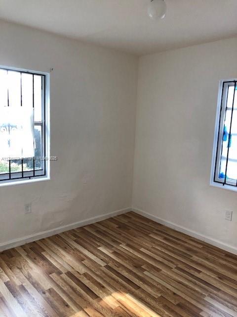 empty room featuring baseboards and wood finished floors