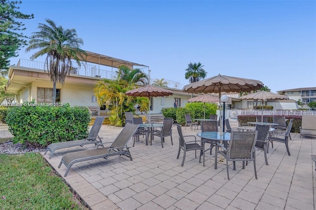 view of patio / terrace featuring fence, outdoor dining space, and a balcony