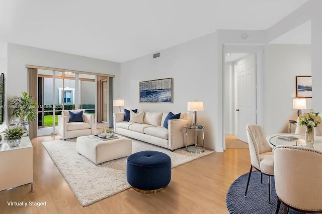 living area with visible vents and wood finished floors