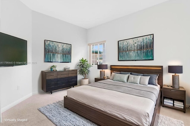 bedroom with light colored carpet and baseboards