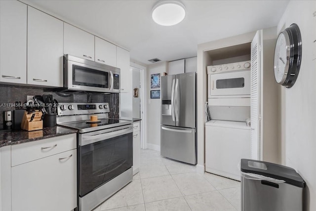 2100 S Ocean Dr Unit 10E, Fort Lauderdale, FL 33316 - kitchen featuring stainless steel appliances, stacked washer / drying machine, visible vents, white cabinetry, and light tile patterned floors