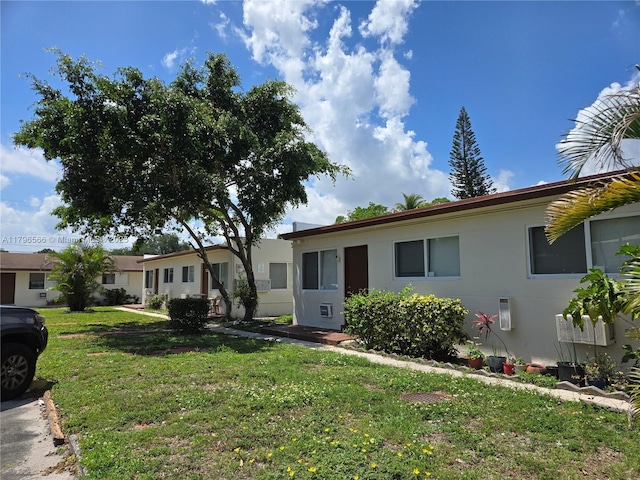 single story home featuring a front yard and stucco siding