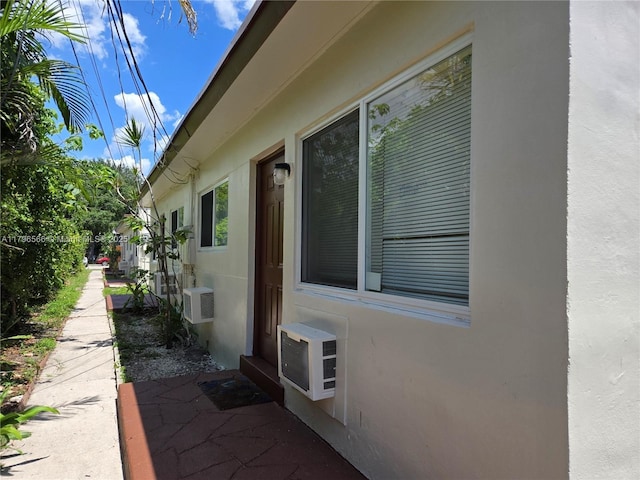 view of property exterior featuring a wall mounted air conditioner and stucco siding