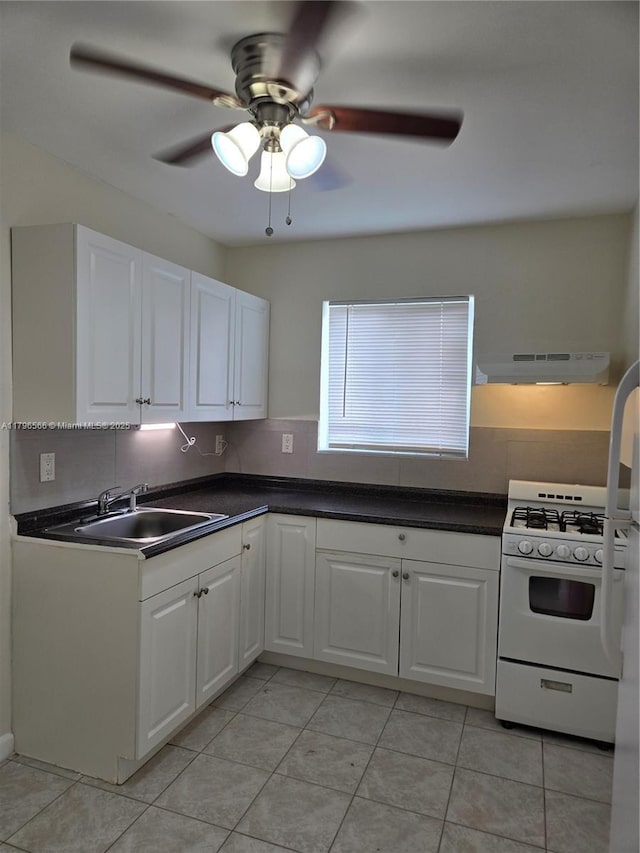 kitchen featuring under cabinet range hood, white cabinetry, a sink, and white gas stove