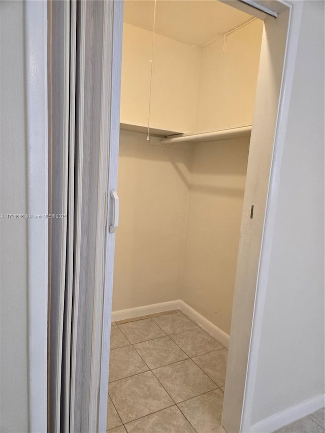 walk in closet with light tile patterned floors