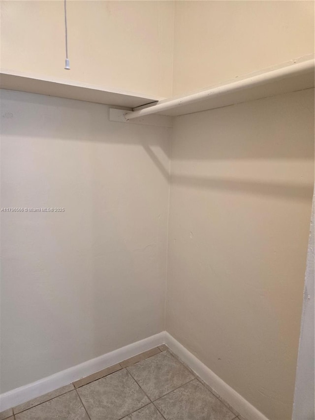 walk in closet with light tile patterned floors